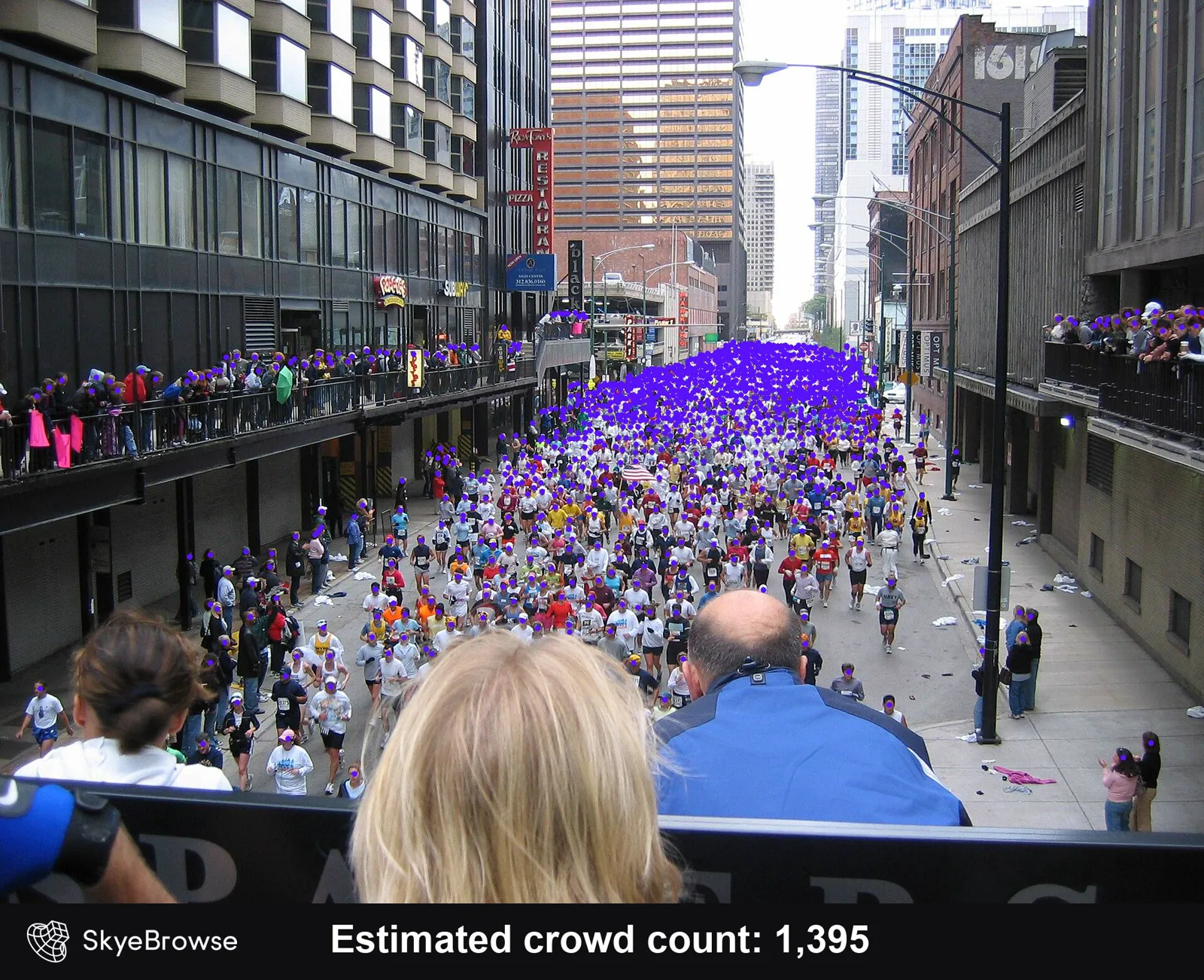 Runners filling a downtown Chicago street with spectators on balconies, each head marked with a purple dot