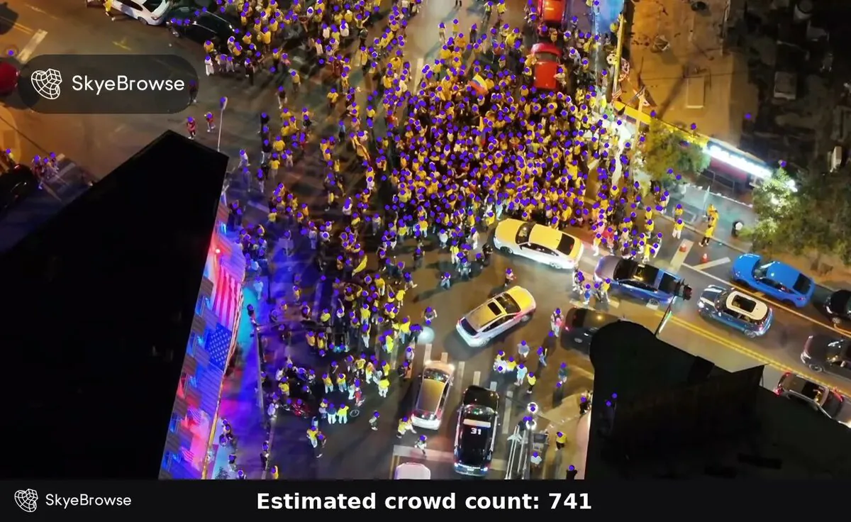 Night drone view of a crowd filling a city intersection, with a purple dot on every detected head and a result bar reading Estimated crowd count: 741